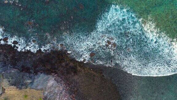 无人机拍摄的海浪冲上海滩的岩石