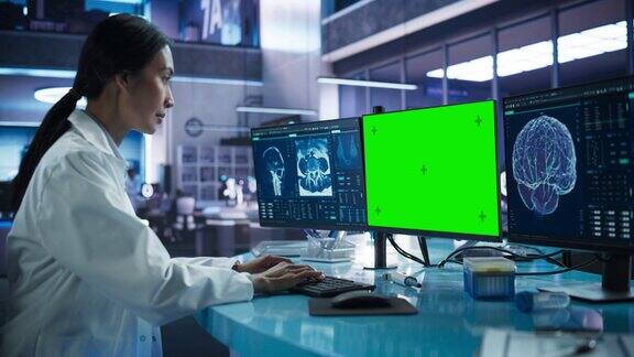医院研究实验室:亚洲女医学家使用电脑绿屏色度展示神经学家分析CT扫描为脑损伤患者找到治疗方法