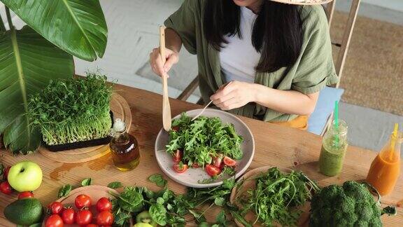 近距离的妇女的手搅拌新鲜的健康素食沙拉与新鲜的有机蔬菜