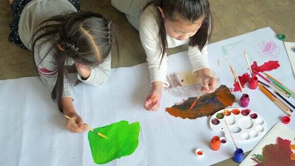 一群幼儿园的亚洲孩子和朋友在学校的美术课上画画