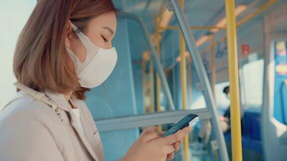 年轻的商业人士在电动汽车上使用手机时戴上医用口罩