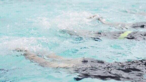 亚洲中国游泳运动员在游泳教练的指导下在泳池边练习腿溅水