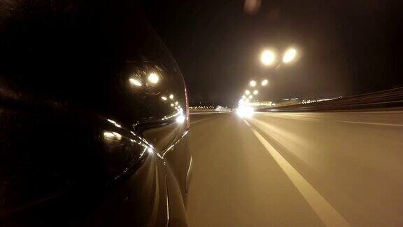 快速城市驾驶夜间道路POV时间推移左侧的汽车低角度后视图
