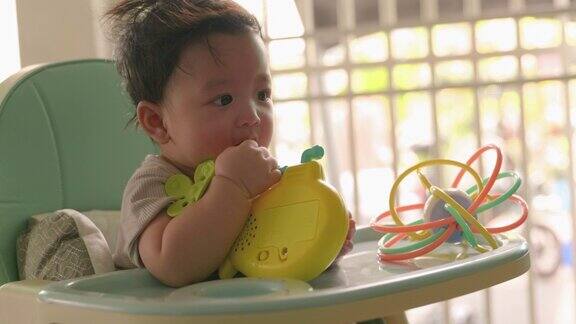 亚洲婴儿正在玩新生儿吸力玩具