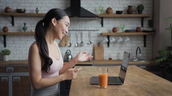 一位健康的亚洲女性正在用笔记本电脑进行视频通话侧视图