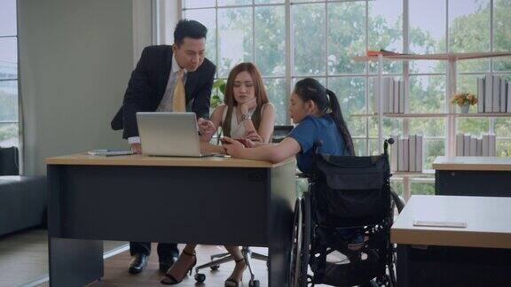 坐在轮椅上的女商人和他的同事在创意办公室进行讨论和头脑风暴