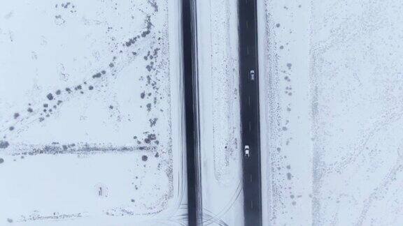 无人机拍摄的是一辆汽车在空旷的雪地里行驶的画面