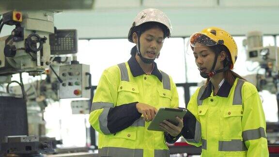 两名女工程师在一家重工业制造工厂使用数码平板电脑