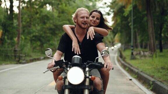 一对夫妇在热带公路上享受骑行