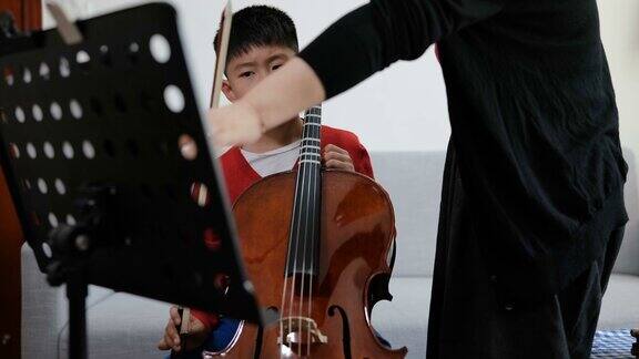 潘宁看悲伤的男孩与老师在家里练习大提琴