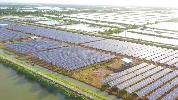 航空太阳能电站或太阳能电池板排日落飞过拍摄和反射附近的道路和湖泊在东南亚