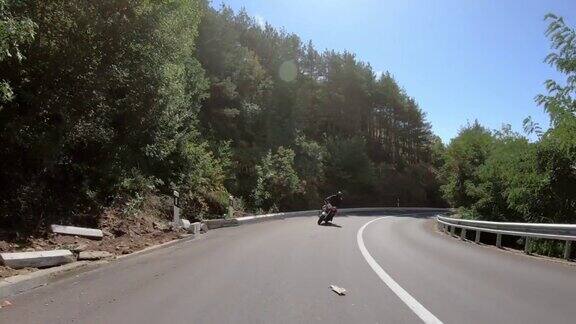 摩托车手在运动摩托车上快速行驶在山路上