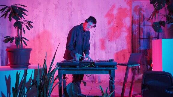 AsianAppearance的现代DJ在霓虹灯下演奏音乐