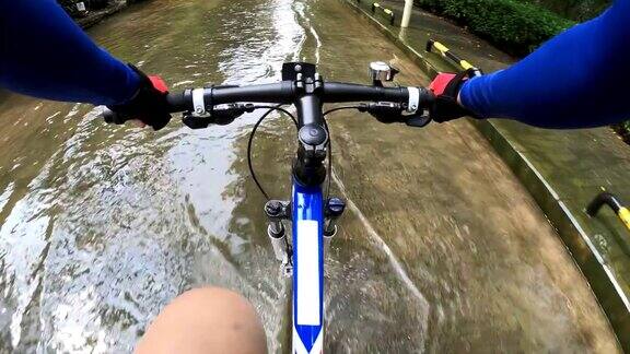 骑自行车的人骑山地车通过水的道路POV
