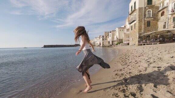 十几岁的女孩在Cefalu古镇的海滩上跳舞