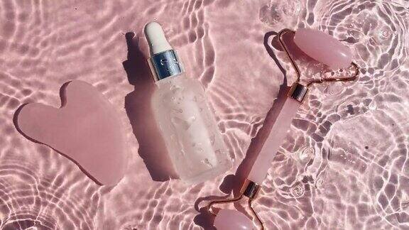 化妆品瓶与移液管在粉红色的背景与水滴纯净水有阳光和阴影的反射缓慢运动的波浪水某保湿护肤品的广告