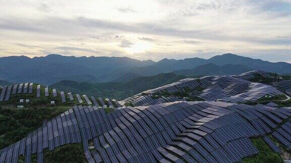 黄昏时分山峦起伏的太阳能发电厂鸟瞰图