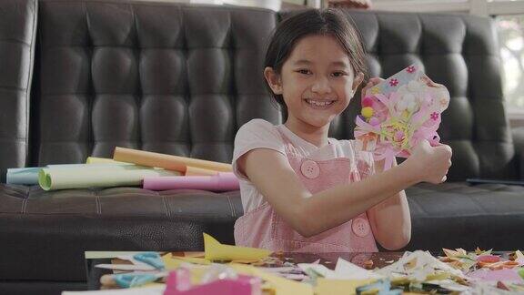亚洲女孩在家剪纸和做她的艺术和手工艺品他们用彩纸、剪刀和胶水在纸上创造艺术项目形成她的想象艺术和工艺概念
