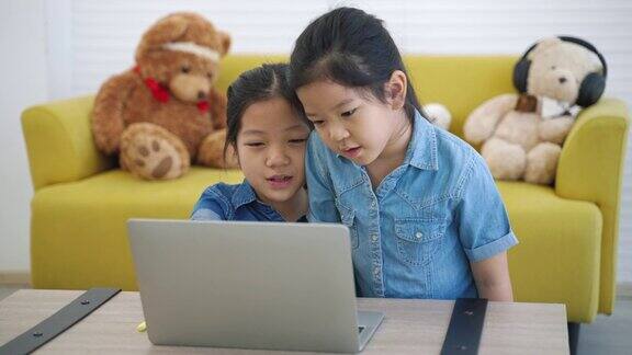 两个亚洲女孩在家上网学习家庭学习社交距离网络学习