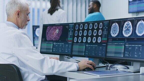 有经验的资深科学家在实验室用个人电脑进行CTMRI脑部扫描图像医学研究中心的神经学家神经科学家致力于脑肿瘤的治疗
