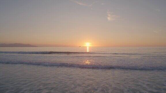日落时美丽的海滩和大海的无人机镜头