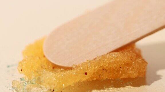 砂糖磨砂膏与清洁颗粒在黄色背景美容宏观纹理