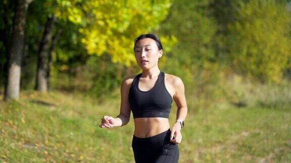 年轻的亚洲快乐女性跑步在森林或城市公园慢跑早晨慢跑积极健康的生活方式健康女性的吸引力体育运动户外