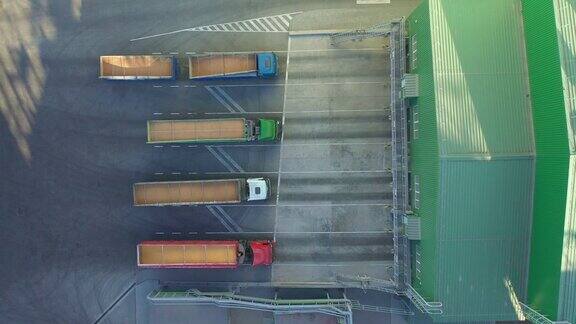从上到下的视图许多卡车与拖车装满粮食等待卸货货物在电梯与仓库