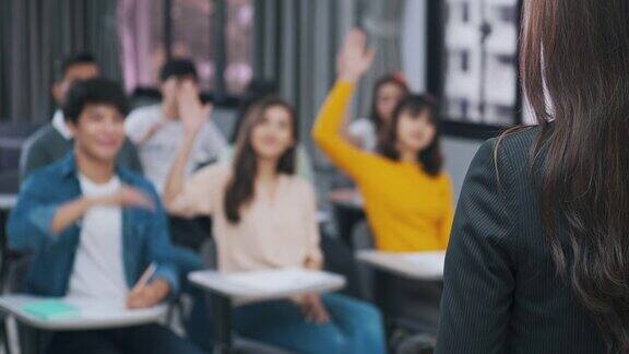 课堂上老师提问和学生举手的后视图