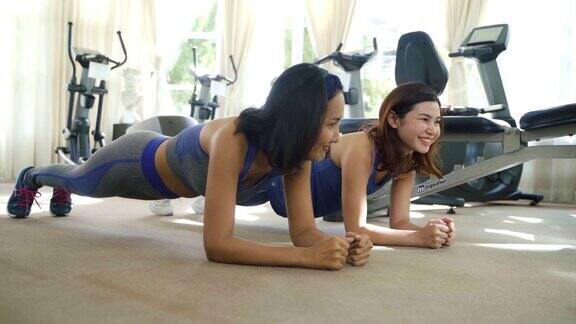 两位亚洲女性在运动服装训练和练习瑜伽教练为健康的生活方式