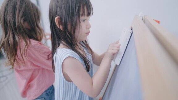 幼儿园的孩子在白板上画画