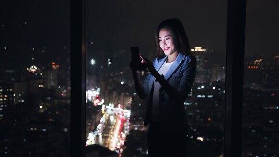 女性在窗户附近使用智能手机