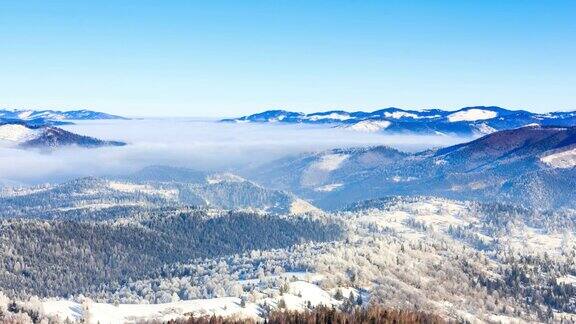 冬天的风景雾在冬天的山上移动天空是蓝色的