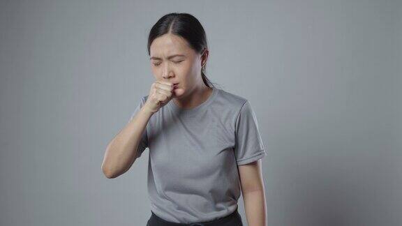 一名亚洲妇女喉咙痛孤立地站在灰色背景上