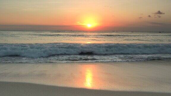 在热带海滩上与破浪宁静的日落