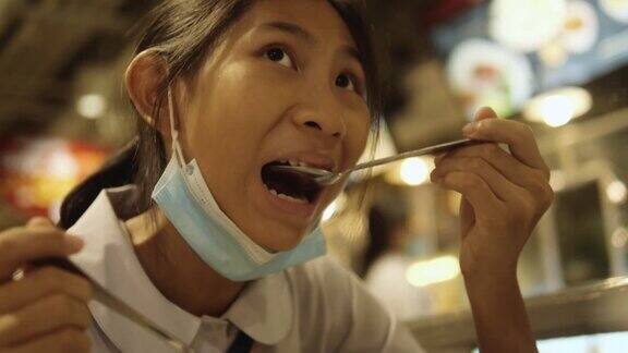 亚洲女学生穿着制服和她的哥哥在美食广场吃汤面生活方式