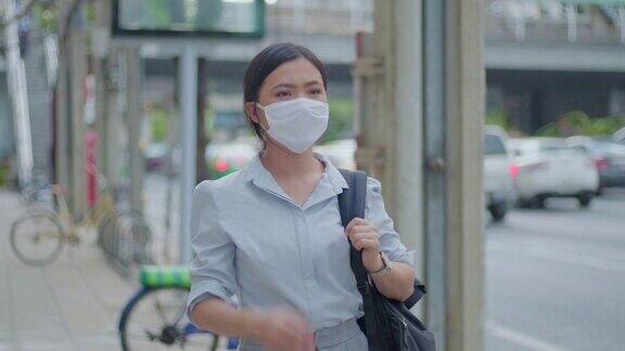 一名亚洲妇女戴着卫生口罩喉咙痛