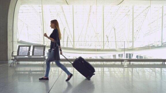 带着行李走过机场候机楼的女人