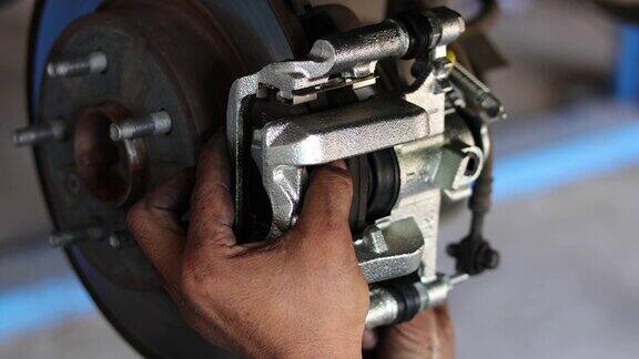 汽车修理工在维修站工作修理起重汽车的车轮、刹车片和蹄片