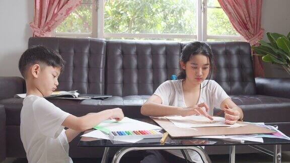 两个男孩和女孩呆在家里在客厅用手指画画画艺术和工艺他们用蜡笔或粉笔的颜色在纸上创造艺术项目形成她的想象艺术和工艺概念