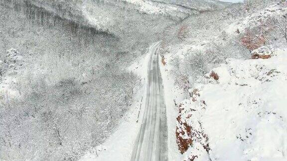 鸟瞰图冬季被雪覆盖的山路驾驶汽车和卡车无人机的顶视图