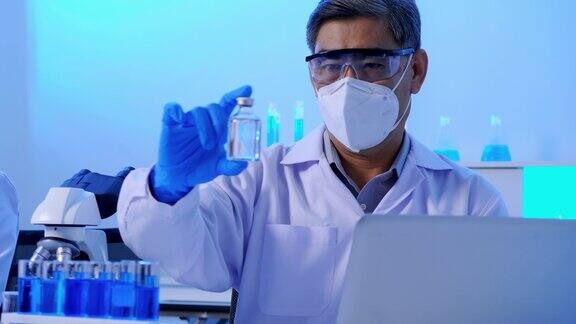 亚洲科学家做一些研究检查瓶中的液体在实验室