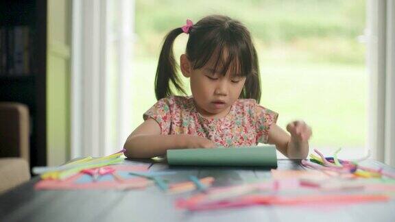 小女孩亲手制作纸工艺品供家庭学习