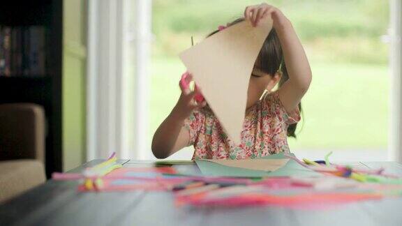 小女孩亲手制作纸工艺品供家庭学习