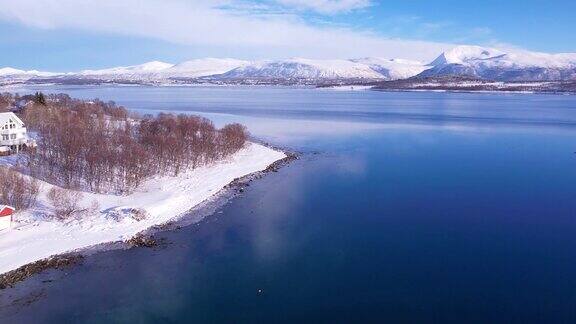 挪威冬季海岸线上白雪覆盖的山脉来自峡湾郡