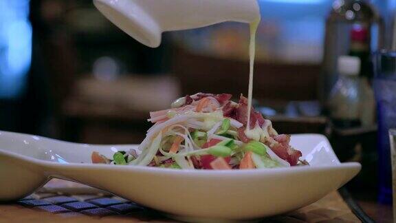 芥末或酱汁浇在混合蔬菜沙拉上烹饪餐厅的健康食品