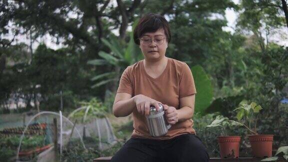 可持续的生活方式亚洲华人中年妇女在后院耕作后休息