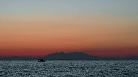 爱琴海上的夕阳移动的船远处的陆地水希腊