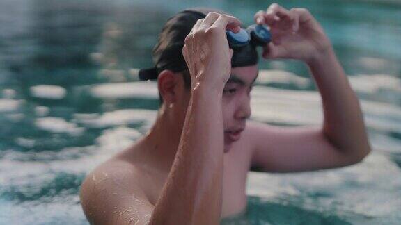 在游泳池游泳的亚洲男子