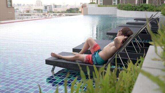 亚洲男人正在私人泳池别墅里享受假期